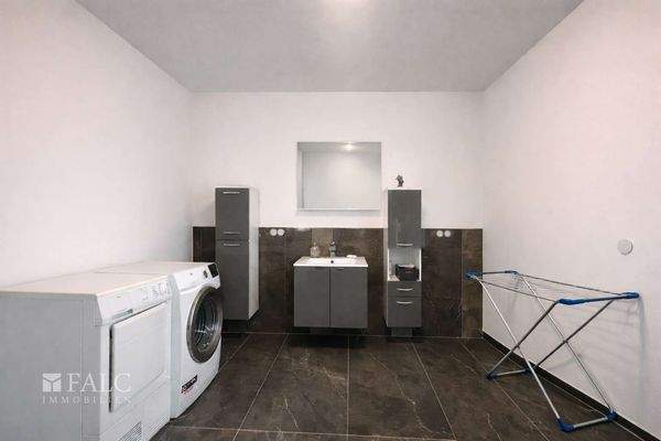 „Funktionaler Technikraum mit integrierter Waschgelegenheit sowie Waschmaschinen- und Trockneranschluss.“