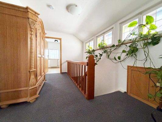 OG: Heller Flur mit schönen, farbigen Fenstern