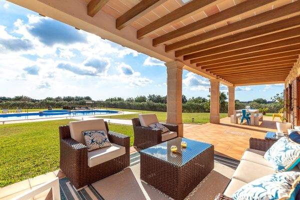 Überdachter Loungebereich mit Poolblick