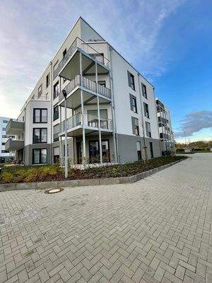 Seitenansicht mit Balkonen und Beeten