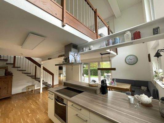 Blick aus der Küche auf den Essbereich und die Terrasse sowie auf die Galerie im Erdgeschoss