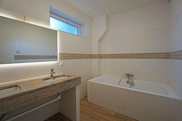 Badezimmer mit Wanne und Doppelwaschtisch aus Rosengranit