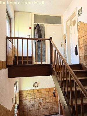 Praktischer Eingangsbereich mit Holztreppe - Clevere Raumnutzung auf mehreren Ebenen