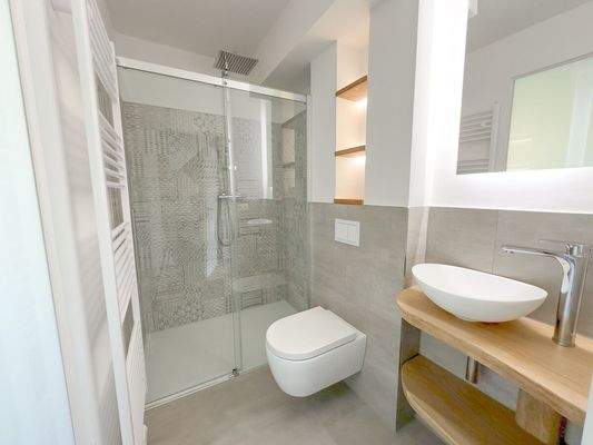 Modernes Bad mit bodengleicher Dusche und klarer Linienführung im EG