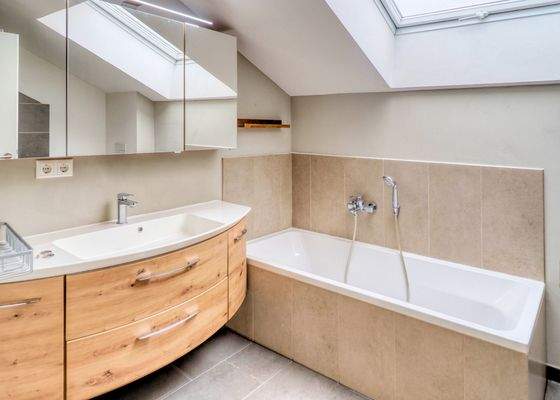 Blick ins Tageslichtbad mit Wanne und Dusche