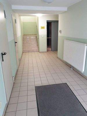 Hauseingang mit Fahrstuhl und Treppe