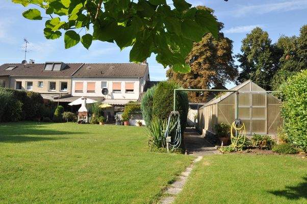 Blick auf Haus und Garten mit Gewächshaus