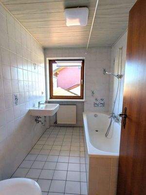 Bad mit Wanne, Waschbecken, Toilette und Fenster
