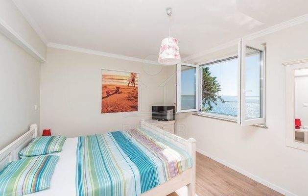 Helles Schlafzimmer mit Blick aufs Meer direkt vom Doppelbett