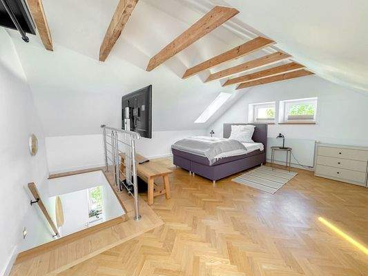 Dachgeschoss mit freigelegten Balken und Fischgrät-Parkett