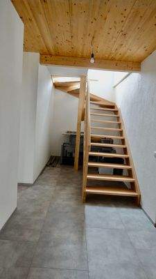 Gang mit edler Massivholztreppe zum OG