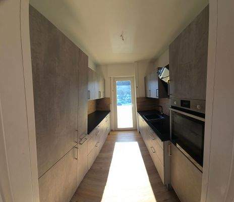 Separater Küchenbereich mit Balkonzugang und einer neuwertiger Einbauküche 