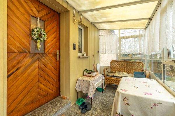 Hauseingangstür über Veranda mit Sitzecke