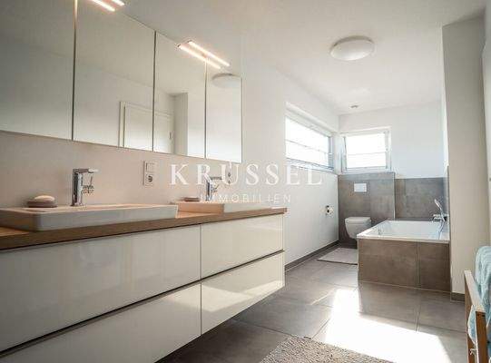 Das Elternbadezimmer mit sowohl Badewanne....