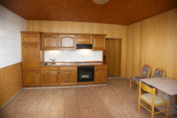 Küche mit Holzregalen und Esstisch.png