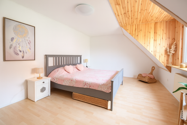 Schlafzimmer mit Holzdecke und floralen Akzenten