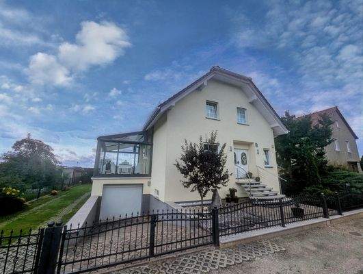 Wohnhausansicht mit Garage, Sommergarten auf der Terrasse