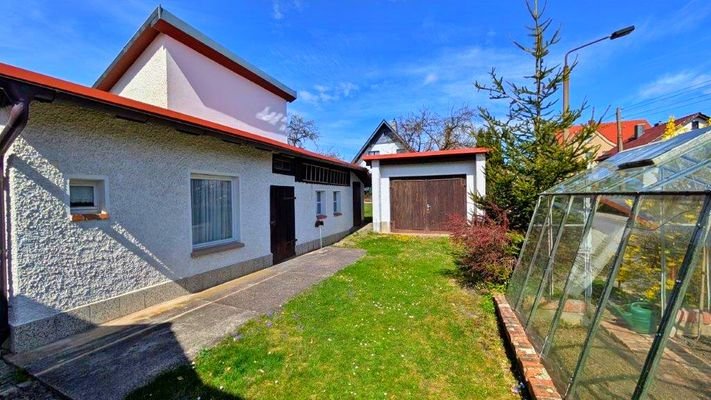 Gartengrundstück vorne mit Garage und Gewächshaus