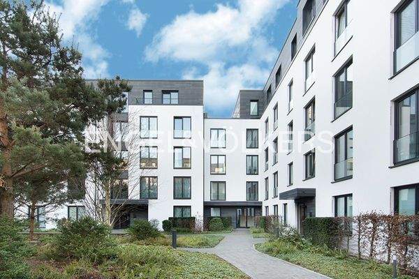 Hausansicht vom grünen Innenhof mit Spielplatz