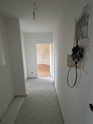 Flur mit Blick in die Wohnung, weiße Bodenfliesen 