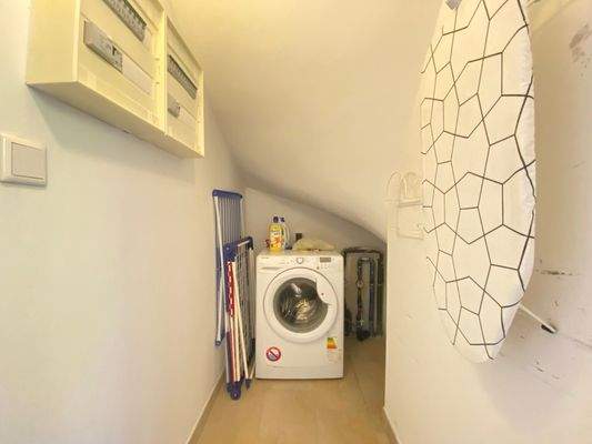Abstellraum im Treppenhaus mit gemeinsamer Waschmaschine