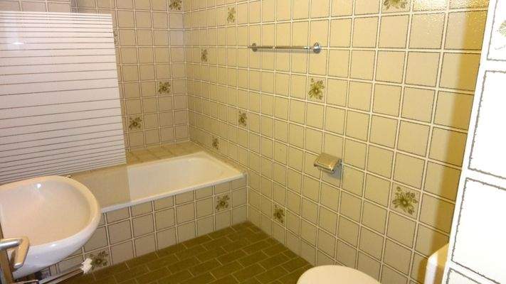 Badezimmer mit Badewanne und WC