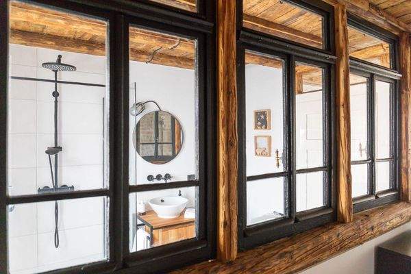 Die alten Außenfenster trennen den Bad- und Schlafbereich