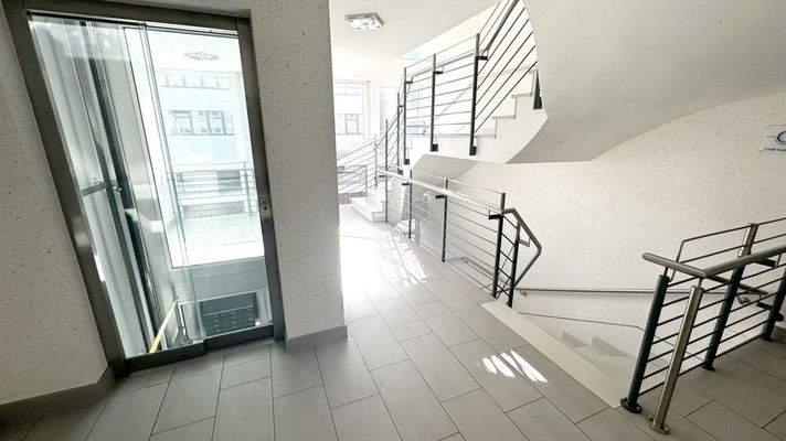 gepflegtes Treppenhaus mit Fahrstuhlanlage