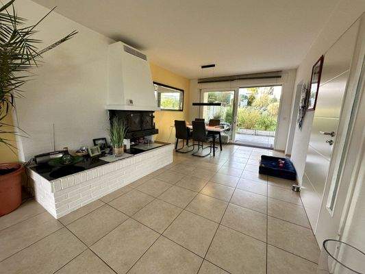 Lichtdurchfluteter Wohn-Essbereich mit elegantem Kamin und direktem Gartenzugang