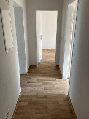 Blick in den Flur mit Zugängen zu den Zimmern und neuem Boden in Holzoptik.jpg