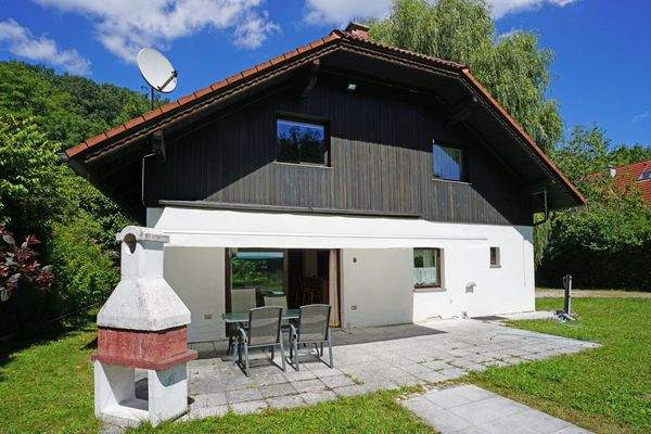 Südwestseitige Hausansicht mit Terrasse mit elektr. Markise und gemauertem Kamin