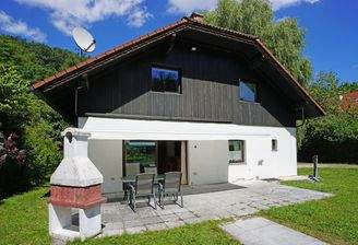 Südwestseitige Hausansicht mit Terrasse mit elektr. Markise und gemauertem Kamin