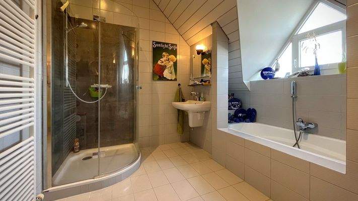 Das Tageslichtbad verfügt über eine Badewanne und eine separate Dusche