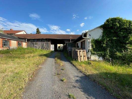 Blick zur Einfahrt vom Grundstück und Blick zu den Nebengebäuden