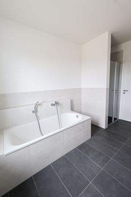Badezimmer mit Badewanne und Dusche