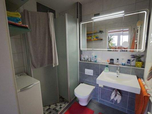 Umfassend modernisiertes Badezimmer mit Waschbecken, WC und bodentiefer Dusche