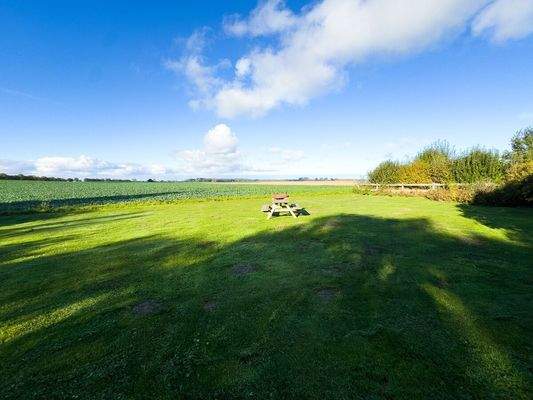Der Blick über Felder und zum Wasser vom Garten