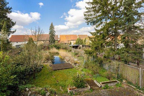 Ausblick aus dem 1. Obergeschoss auf den Garten mit Schwimmteich