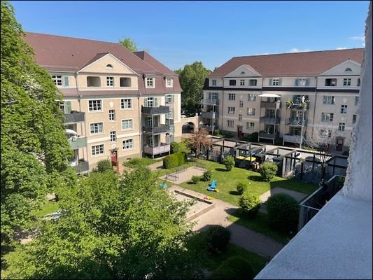 Blick von der Loggia in den ruhigen, sonnigen Innenhof