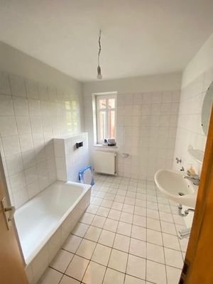 Badezimmer mit Badewanne und Fenster