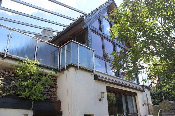 Glasfront des Dachgeschosses, Balkone rechts und links