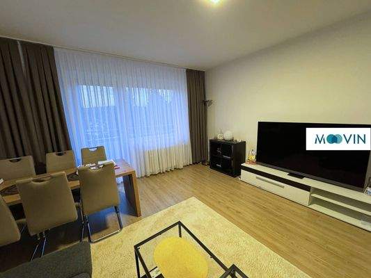 Ansicht II: Großzügiges Wohnzimmer mit Zugang zum Balkon