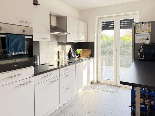 Küche mit moderner Einbauküche und Zugang zur Terrasse