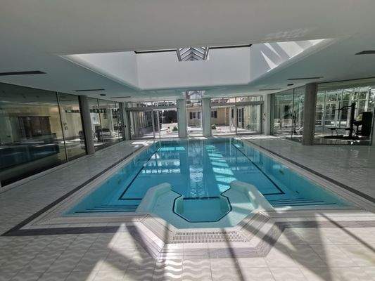 Spabereich Schwimmhalle mit modernem Pool und großen Glasfronten