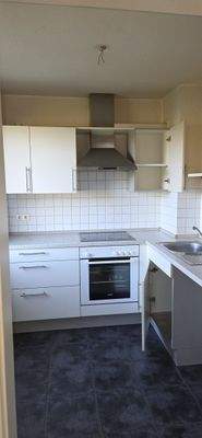 Küche mit Einbauküche und Fenster