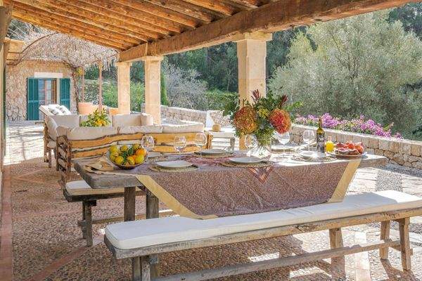 Überdachte Terrasse mit Esstisch und mediterranem Ambiente