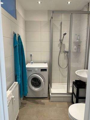 Badezimmer mit Dusche und Waschmaschine