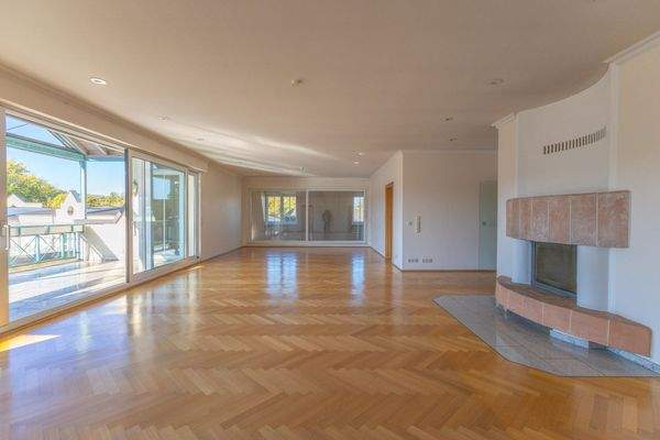 Großes Wohnzimmer mit Kamin und Zugang zum großen, 
überdachten Balkon