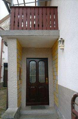 Hauseingang mit darüberliegenden Balkon