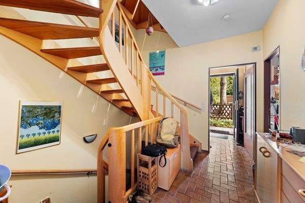 Heller Flur mit attraktiver Holztreppe